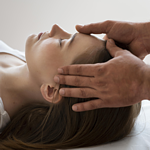 Frauenkopf auf dem R�cken liegend mit Therapeutenh�nden